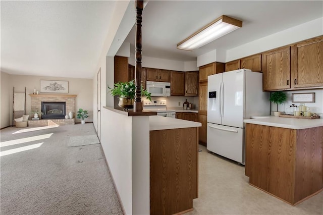 kitchen featuring white appliances, brown cabinetry, a peninsula, light carpet, and open floor plan