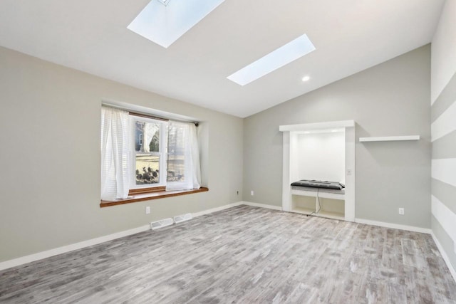 unfurnished living room with visible vents, lofted ceiling, baseboards, and wood finished floors