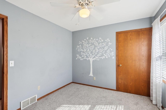 unfurnished bedroom featuring carpet flooring, baseboards, visible vents, and ceiling fan