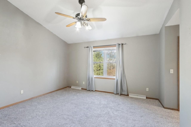 carpeted spare room with visible vents, baseboards, a ceiling fan, and vaulted ceiling