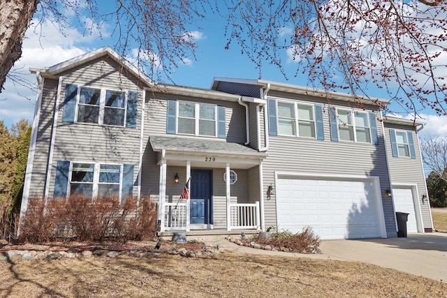 view of front of house with concrete driveway, an attached garage, and a porch