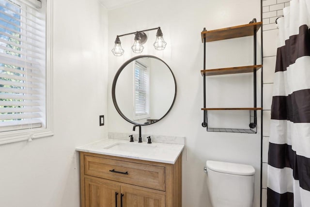 bathroom featuring plenty of natural light, toilet, curtained shower, and vanity