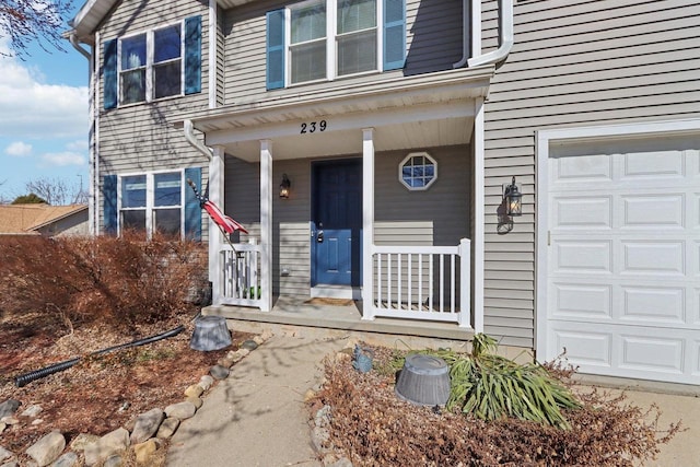 entrance to property featuring covered porch and a garage