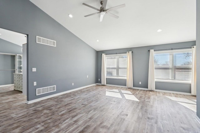 unfurnished room featuring visible vents, high vaulted ceiling, baseboards, and wood finished floors