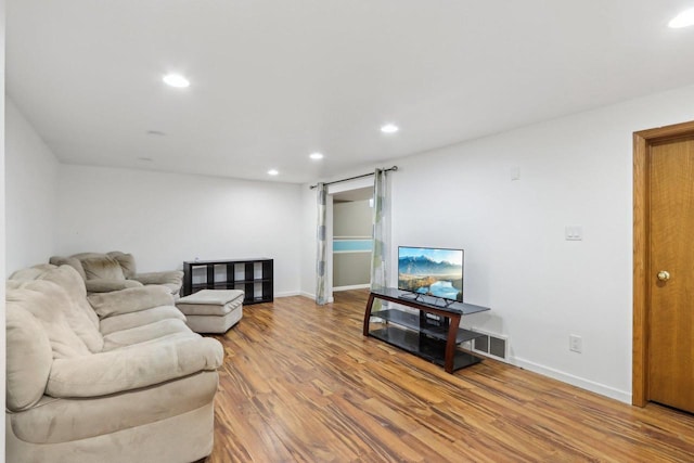 living room featuring recessed lighting, visible vents, baseboards, and wood finished floors