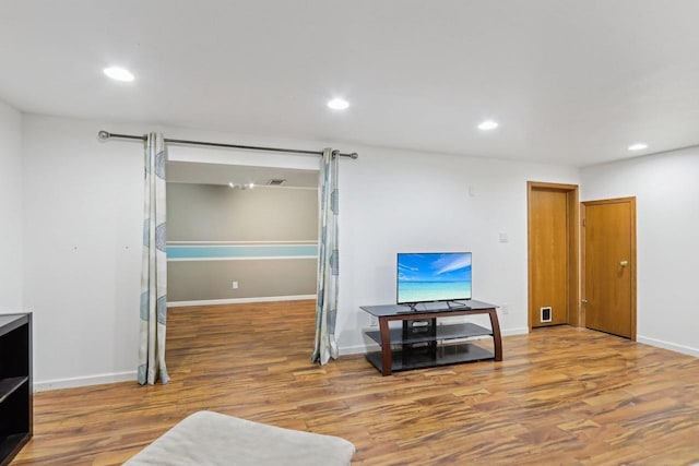 living area featuring recessed lighting, wood finished floors, and baseboards