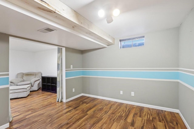 below grade area featuring wood finished floors, visible vents, and baseboards