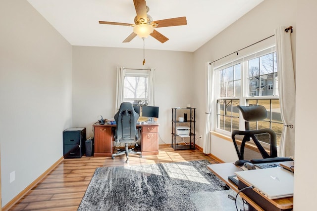 office area featuring light wood-style flooring, a ceiling fan, and baseboards