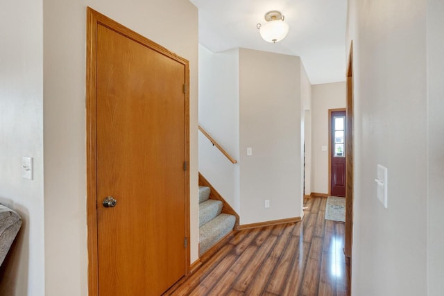 hall featuring stairway, wood finished floors, and baseboards