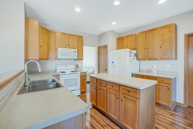 kitchen with white appliances, light countertops, light wood-style floors, and a sink