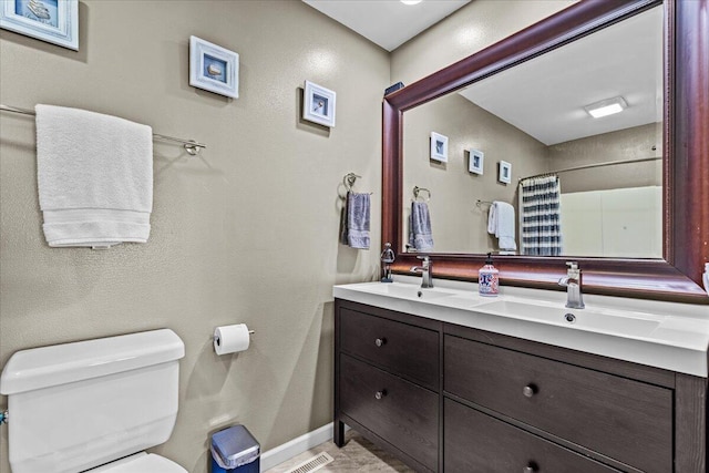 bathroom featuring curtained shower, toilet, baseboards, and a sink