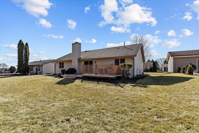 rear view of property with a wooden deck, a yard, and a chimney