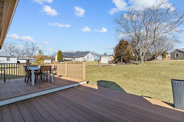 wooden deck with a yard, a residential view, and outdoor dining space