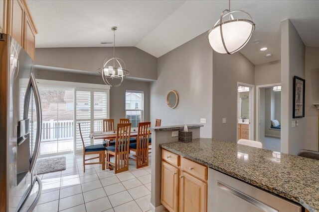 kitchen with light tile patterned floors, light brown cabinets, visible vents, lofted ceiling, and stainless steel fridge