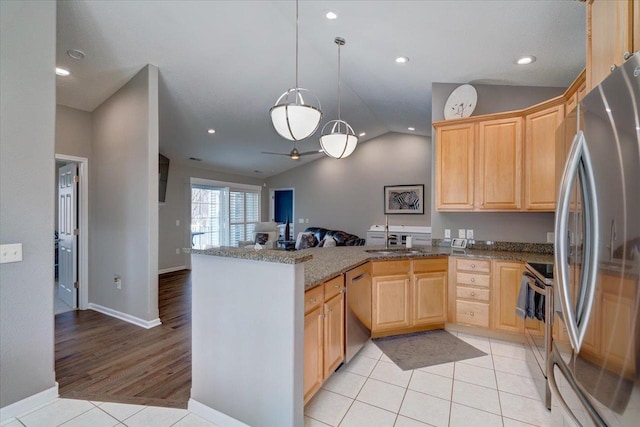 kitchen with light tile patterned floors, light brown cabinets, open floor plan, and appliances with stainless steel finishes