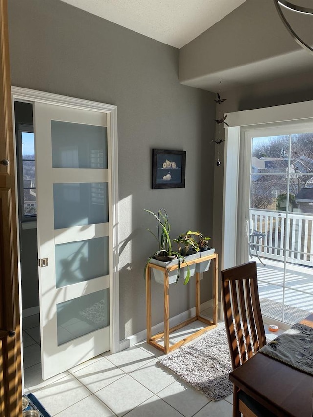 dining area with baseboards and tile patterned flooring