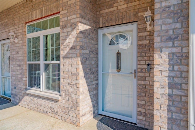 doorway to property featuring brick siding