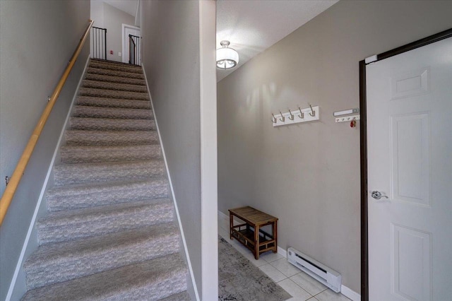 stairway featuring tile patterned flooring, baseboard heating, and baseboards