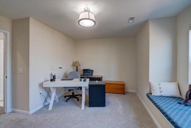 office area featuring visible vents, light colored carpet, baseboards, and a textured ceiling