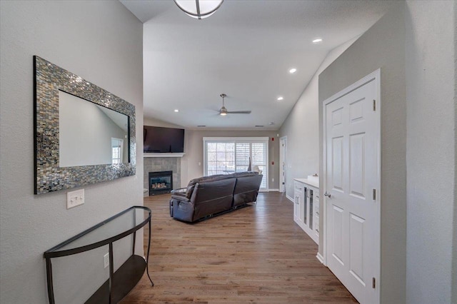 corridor with recessed lighting, baseboards, wood finished floors, and vaulted ceiling