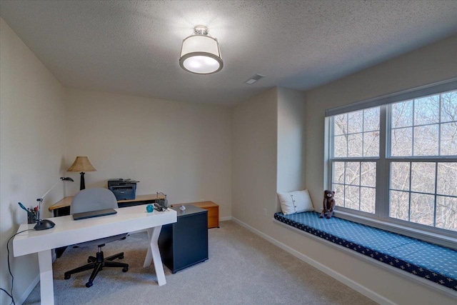 carpeted office space featuring visible vents, baseboards, and a textured ceiling