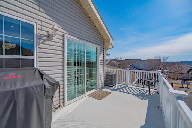 view of wooden balcony featuring a deck, central AC unit, and a grill