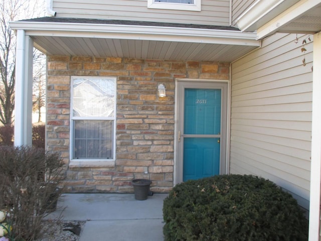 property entrance with stone siding and brick siding