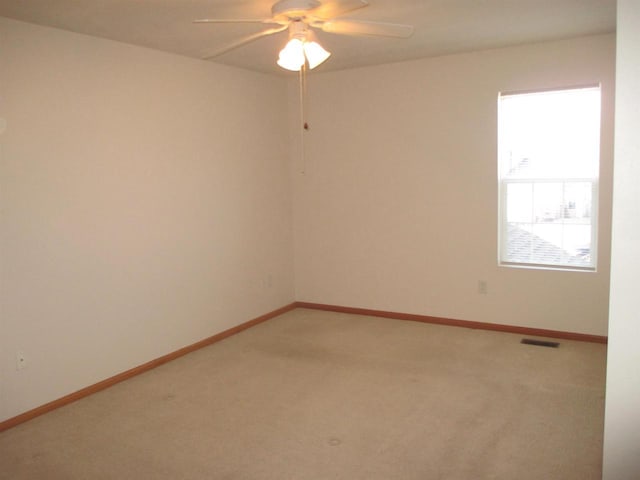 unfurnished room featuring light carpet and baseboards