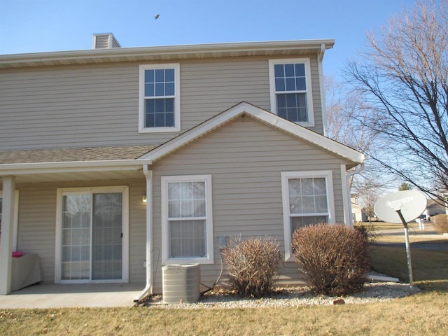 back of property featuring central AC and roof with shingles