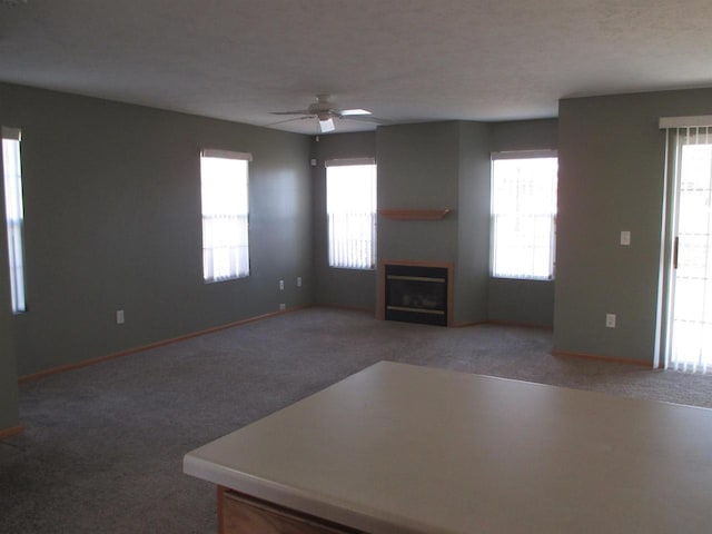 unfurnished living room featuring a fireplace, carpet floors, and a healthy amount of sunlight