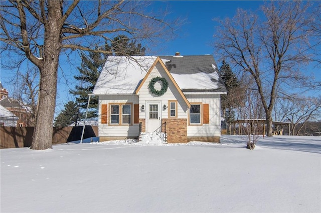 view of front facade with a chimney and fence