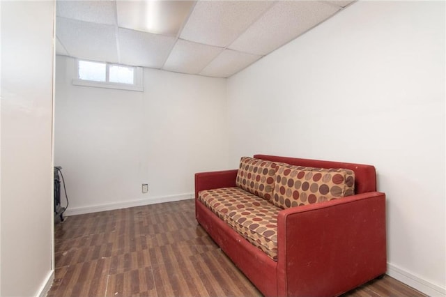 sitting room featuring a paneled ceiling, baseboards, and wood finished floors