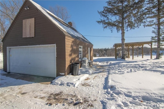 view of snow covered exterior featuring a detached garage, an outbuilding, a barn, and a chimney