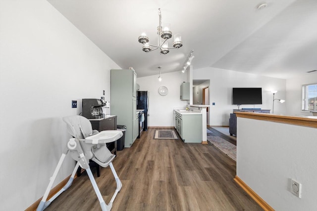 kitchen featuring baseboards, light countertops, lofted ceiling, an inviting chandelier, and dark wood-style floors