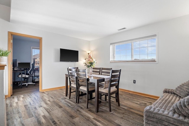 dining room featuring wood finished floors, visible vents, and a healthy amount of sunlight