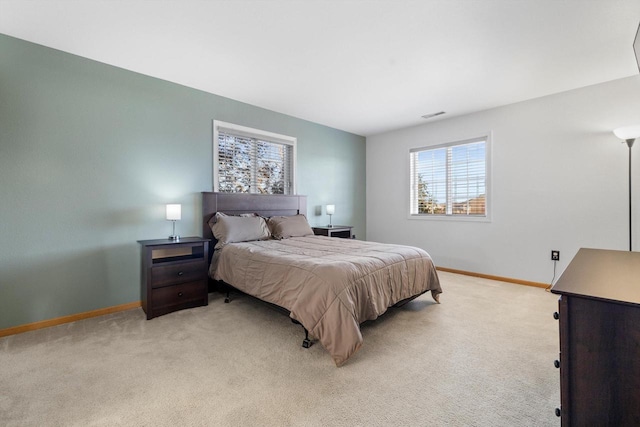 bedroom featuring light carpet, visible vents, and baseboards