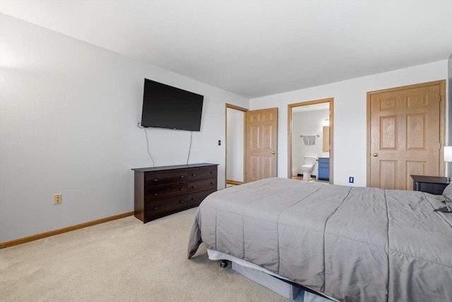 carpeted bedroom featuring baseboards and ensuite bathroom