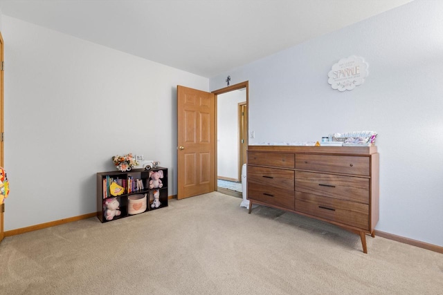 bedroom with light colored carpet and baseboards