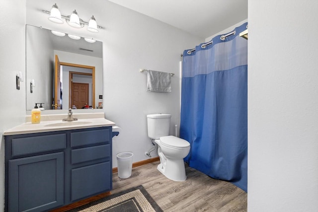 bathroom featuring vanity, wood finished floors, baseboards, curtained shower, and toilet