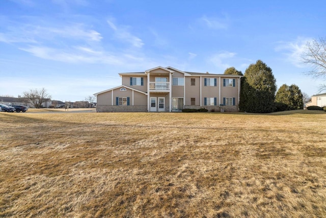 view of front of house featuring a front yard and a balcony