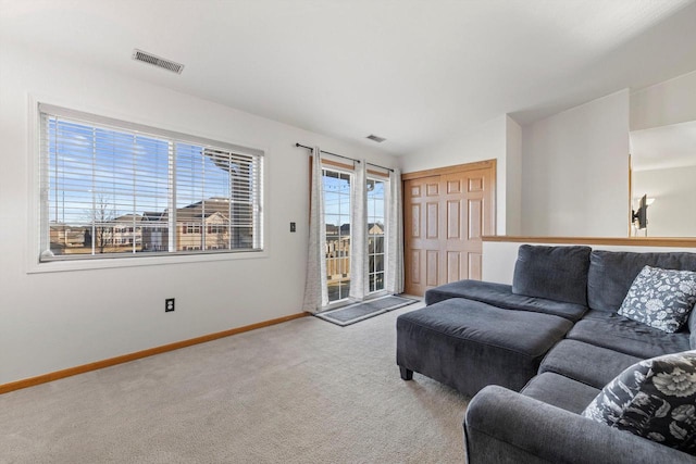 carpeted living room with lofted ceiling, visible vents, and baseboards