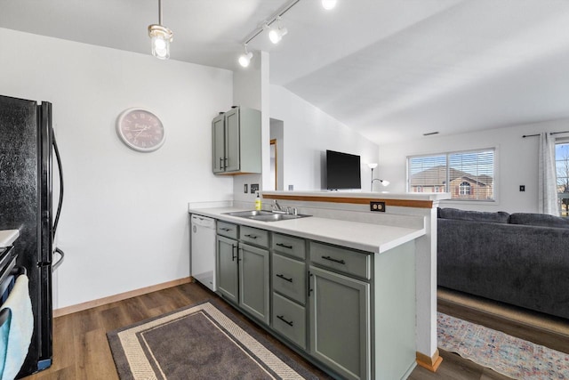 kitchen with a peninsula, white dishwasher, a sink, vaulted ceiling, and open floor plan