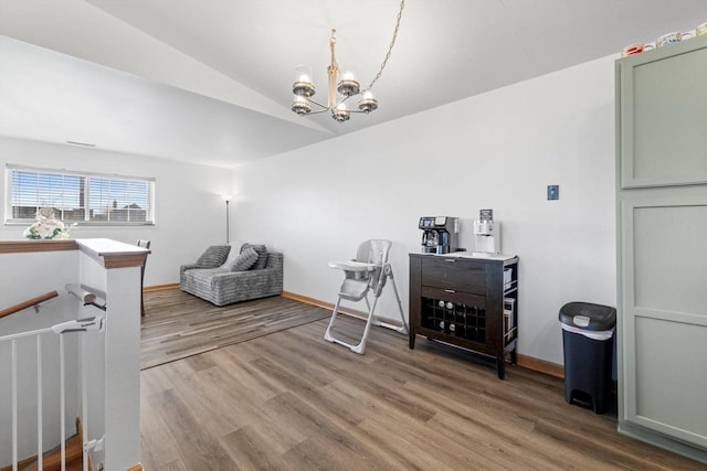 living area with baseboards, an upstairs landing, a notable chandelier, and light wood-style flooring