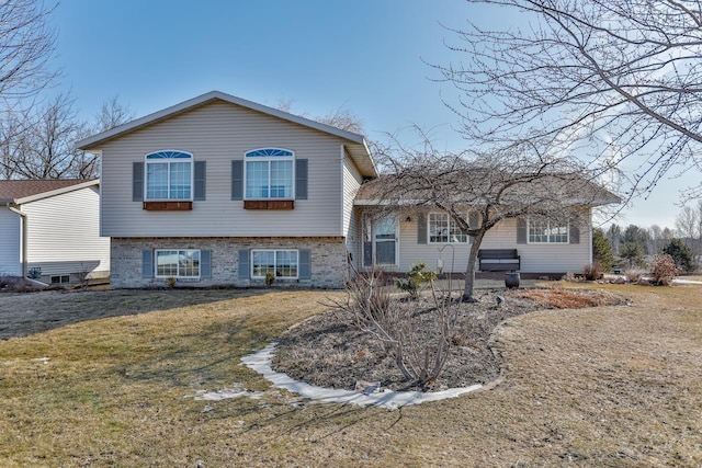 tri-level home featuring brick siding and a front lawn