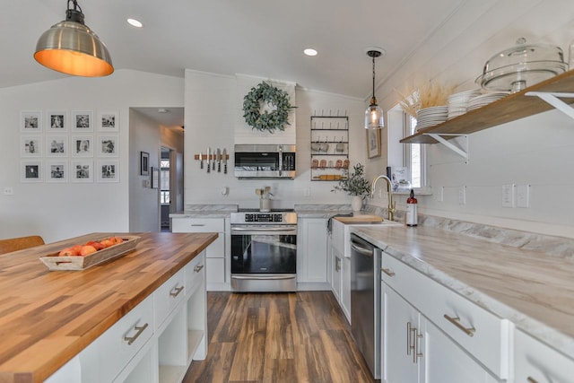 kitchen with butcher block countertops, white cabinets, stainless steel appliances, and open shelves