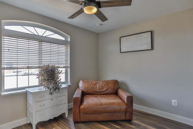 living area with baseboards, wood finished floors, and a ceiling fan