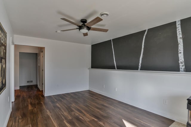 empty room featuring visible vents, ceiling fan, baseboards, and wood finished floors