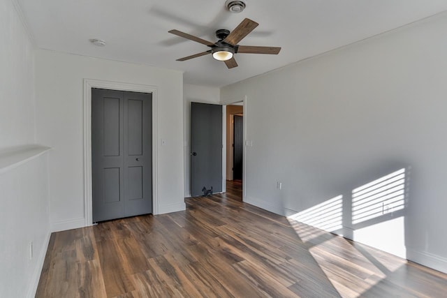 unfurnished bedroom featuring visible vents, baseboards, ceiling fan, and dark wood-style flooring