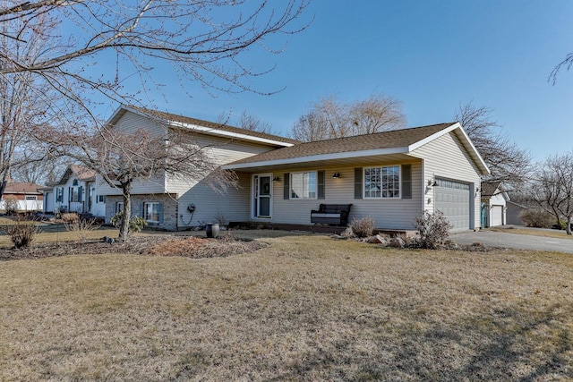 split level home with a front lawn, a garage, and driveway