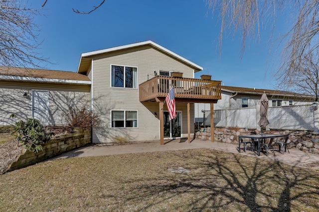 back of property with a deck, a lawn, a patio, and fence